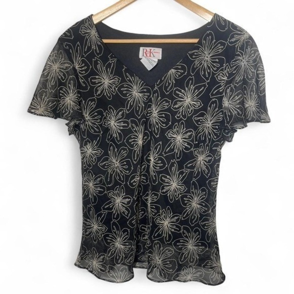 Black and white floral blouse with short sleeves and subtle ruffle trim